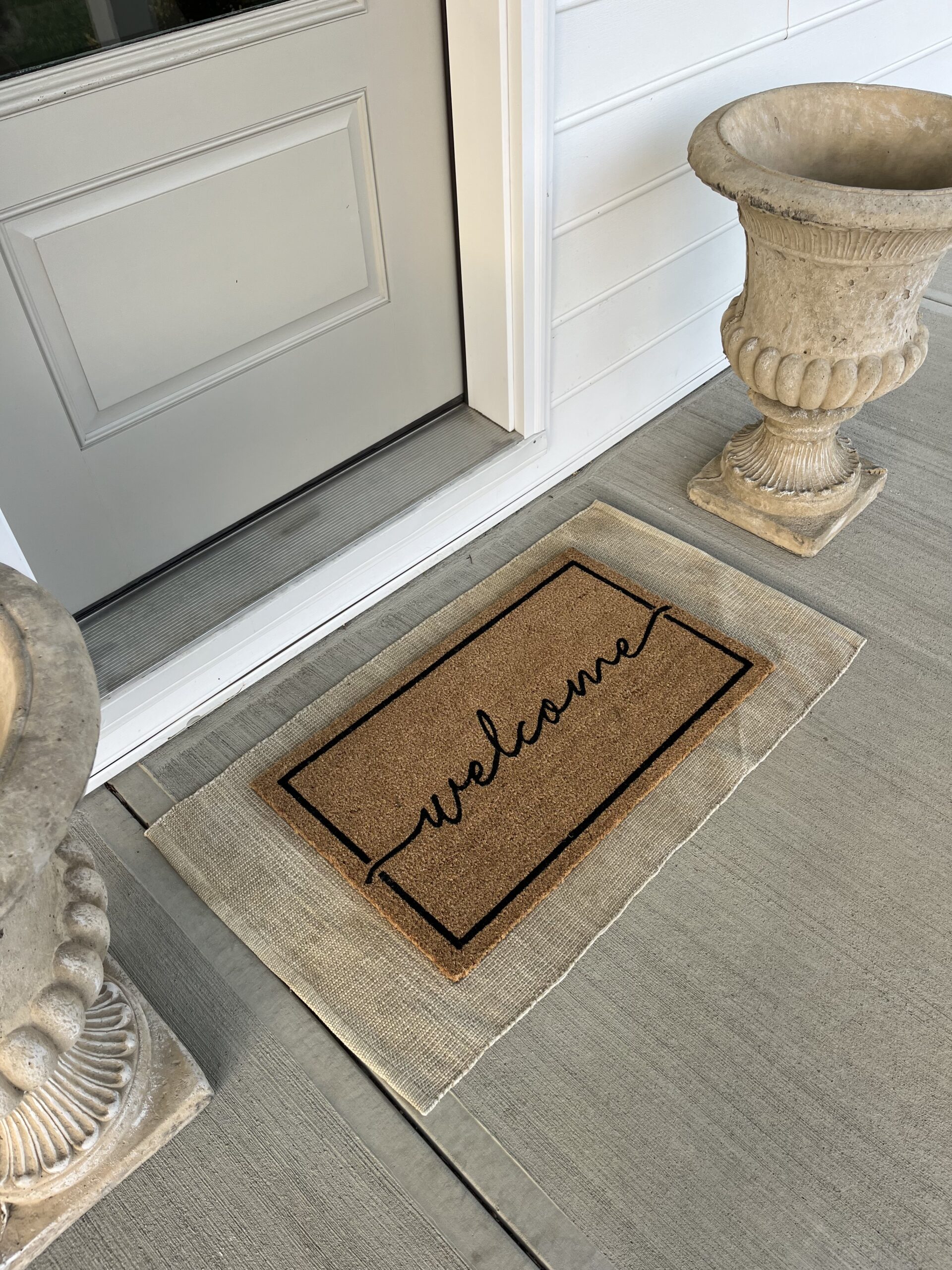 layered welcome mat with concrete planter